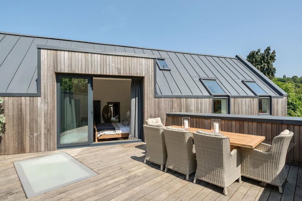 The sunny roof terrace at Hidden House with views across the valley